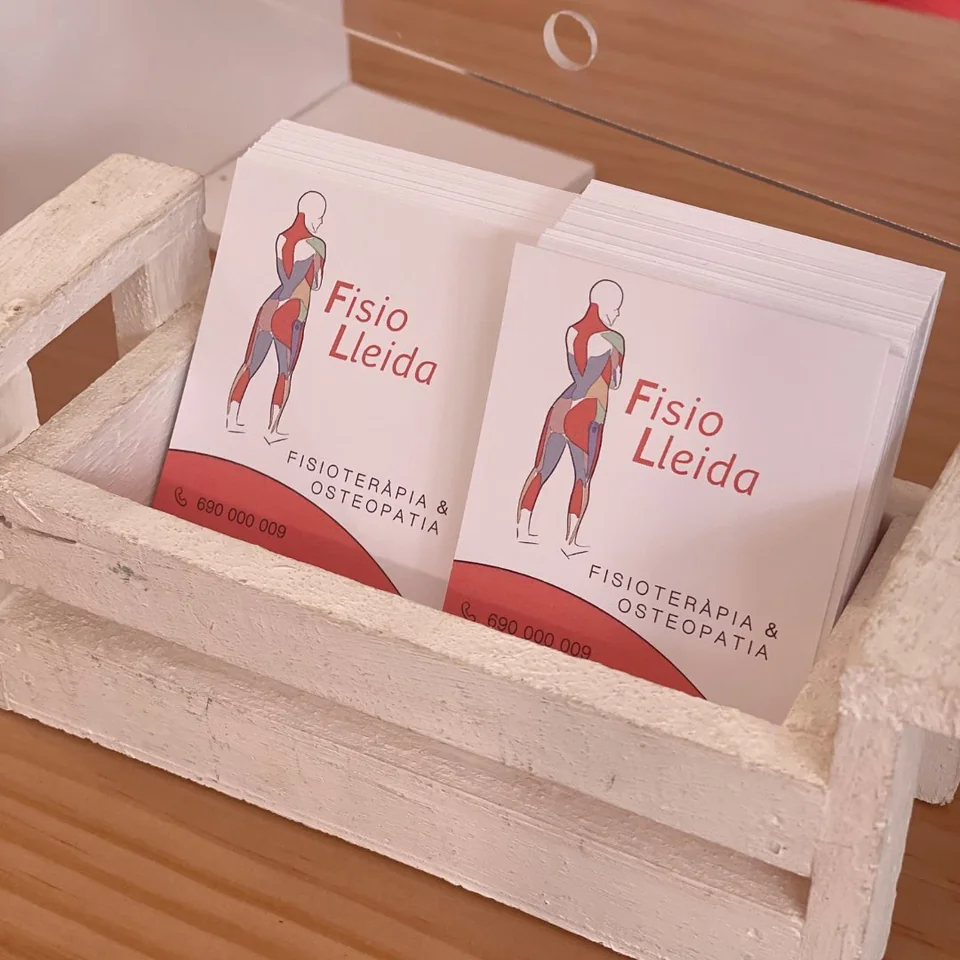 Targetes de FisioLleida en un suport de fusta